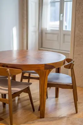 a wooden table and two chairs and a table and a door at Almada 151 - 2F in Porto