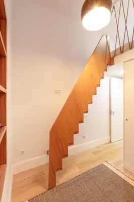 a staircase in a home with white walls and wooden floors at VIVA João IV Residence Studios in Porto