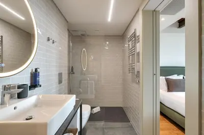 a bathroom with a sink and a toilet and a bed at Republica 144 Apartamentos by DA'Home in Porto