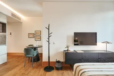 a bedroom with a bed and a desk and a tv at Republica 144 Apartamentos by DA'Home in Porto