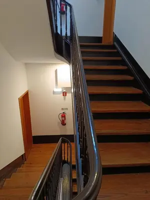 a staircase in a building with a fire extinguisher on the wall at Porto Alma 388 - Silent city center in Porto