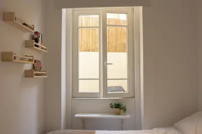 a room with a window with a plant on a table at T2 Pedra do Bonfim, Centro do Porto com Pátio e Churrasqueira in Porto
