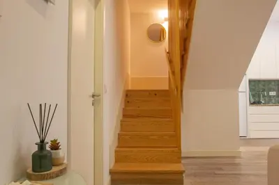 a stairway in a home with white walls and wooden floors at T2 Pedra do Bonfim, Centro do Porto com Pátio e Churrasqueira in Porto