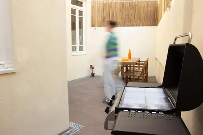 a man walking through a room with a table at T2 Pedra do Bonfim, Centro do Porto com Pátio e Churrasqueira in Porto