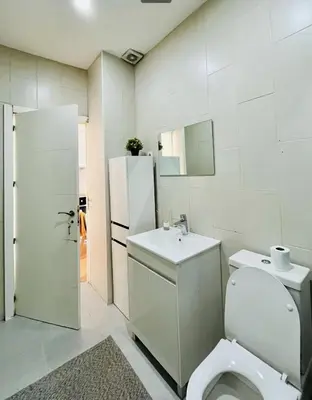 a white bathroom with a toilet and a sink at Porto Boavista Patio House in Porto