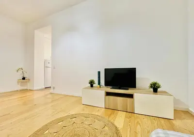 a living room with a flat screen tv on a cabinet at Porto Boavista Patio House in Porto