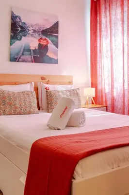 a bedroom with a white bed with a red blanket at NEW! Gaia Arrabida in Vila Nova de Gaia