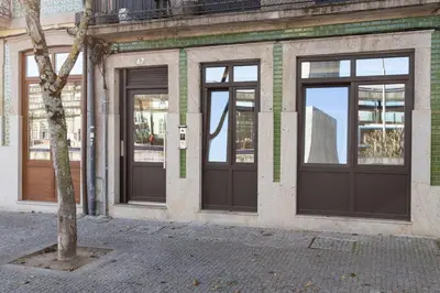 a building with three doors and a tree in front at GuestReady - Fantastic Porto Flat in Porto