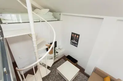 a spiral staircase in a room with white walls at Rosario Duplex in Porto