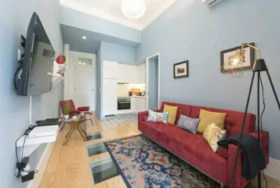 a living room with a red couch and a tv at Wine Cellar by Upperground in Porto