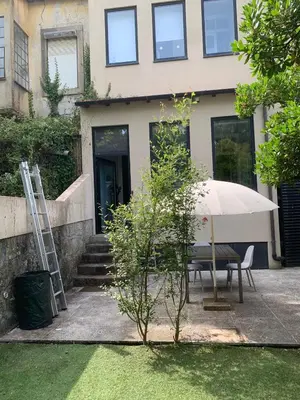 a table with an umbrella in front of a house at Wine Cellar by Upperground in Porto