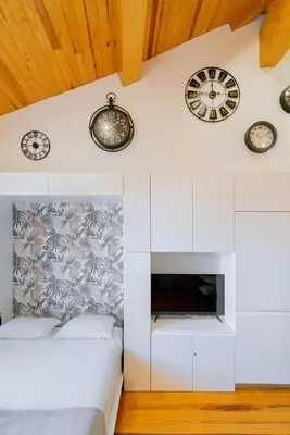 a bedroom with clocks on the wall and a bed at Cozy Stay w/ AC and View in Porto