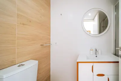 a bathroom with a toilet and a mirror at Cozy Stay w/ AC and View in Porto
