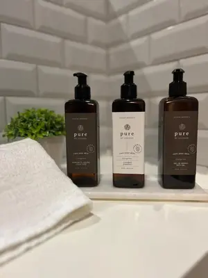 three bottles of soap and a towel on a shelf at Historical Corner by Upperground in Porto