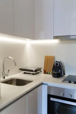 a white kitchen with a sink and a stove at Heart of Porto by Upperground in Porto