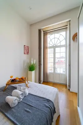 a bedroom with a large bed and a large window at Heart of Porto by Upperground in Porto