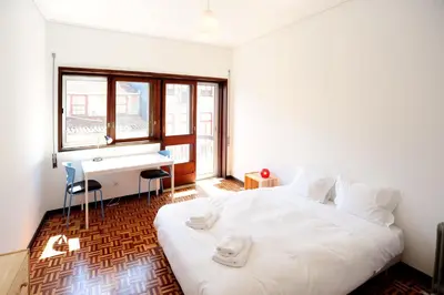 a bedroom with a white bed and a desk at Baron Omega in Porto