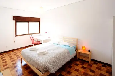 a bedroom with a bed and a desk and a chair at Omega White in Porto