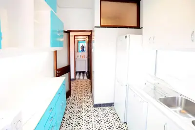 a kitchen with blue cabinets and a tiled floor at Omega White in Porto
