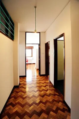 an empty hallway with wooden floors and doors at Omega White in Porto