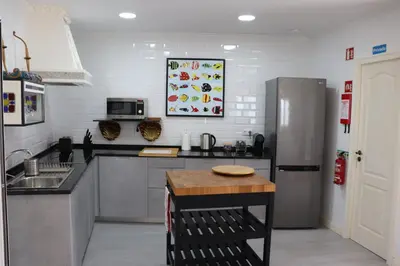a kitchen with a stainless steel refrigerator and a table at Well at Home in Vila Nova de Gaia