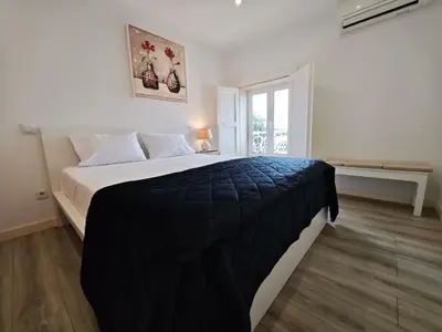 a bedroom with a large bed with a black blanket at Well at Home in Vila Nova de Gaia
