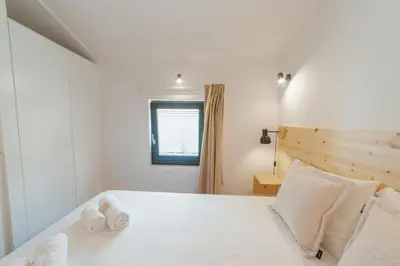 a bedroom with a white bed with towels on it at Cedofeita Loft by Hosty in Bicas