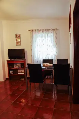 a dining room with a table and chairs and a television at Sailor's House 3 - Casa dos Bibos in Porto