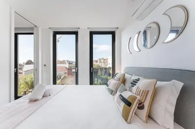 a white bedroom with a large bed with windows at Candy Crush in Porto