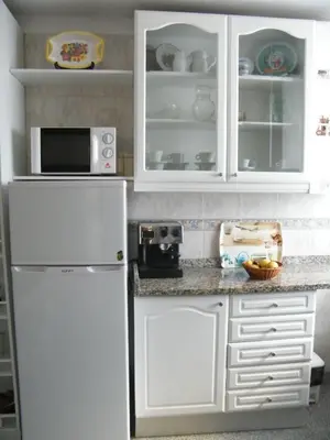 a kitchen with white cabinets and a white refrigerator at Sailor's House - Holiday's House in Porto
