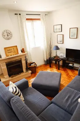 a living room with a blue couch and a fireplace at Sailor's House - Holiday's House in Porto
