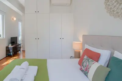 a bedroom with a large bed with colorful pillows at Ps70 II in Porto