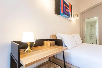 a bedroom with a bed and a desk with a lamp at Modern Retro Downtown by LovelyStay in Porto