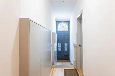 a hallway with a blue door in a white room at Modern Retro Downtown by LovelyStay in Porto