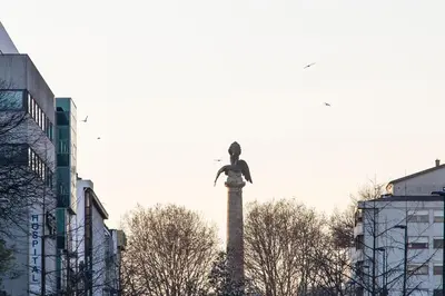 a statue on top of a tower in a city at Modern Retro Downtown by LovelyStay in Porto