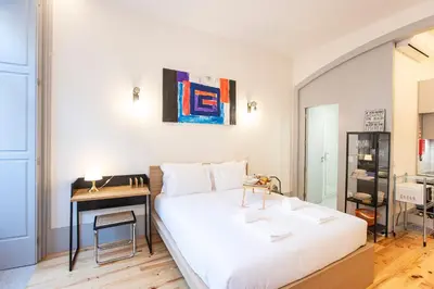 a bedroom with a bed with a desk and a painting at Modern Retro Downtown by LovelyStay in Porto