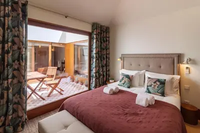 a bedroom with a large bed and a balcony at Garden of Eden - 2 bdrs, elevator, AC and terrace in Porto