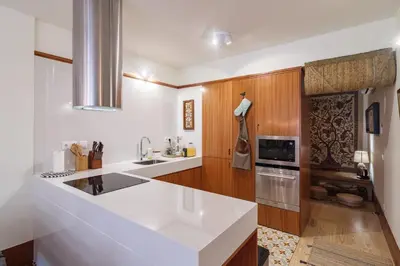 a kitchen with a white counter top and wooden cabinets at Garden of Eden - 2 bdrs, elevator, AC and terrace in Porto