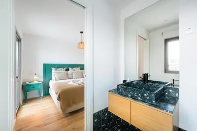 a bedroom with a bed and a sink and a mirror at GuestReady - Splendid Retreat in Porto in Porto
