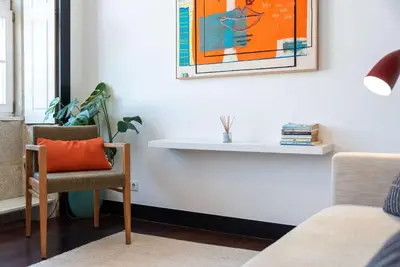a desk with a chair and a picture on the wall at Large Studio with City Views in Porto