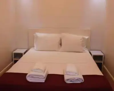 a bedroom with a bed with two towels on it at Alegria Street Flat in Porto