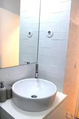 a white sink in a bathroom with a mirror at Alegria Street Flat in Porto