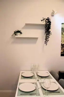 a white table with plates and wine glasses on it at Alegria Street Flat in Porto