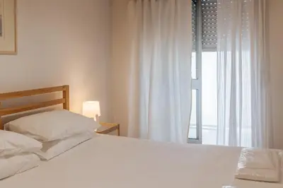 a bedroom with a white bed and a window at Palácio de Cristal, Porto Apartment by Mycelia in Porto