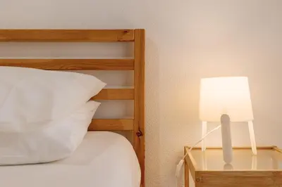a bed with a white pillow and a lamp at Palácio de Cristal, Porto Apartment by Mycelia in Porto