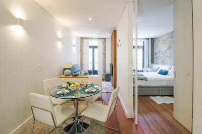 a room with a table and chairs and a bedroom at Almada Comfy in Porto