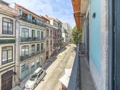 a white car parked on a street with buildings at Almada Comfy in Porto