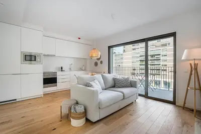 a living room with a couch and a kitchen at GuestReady – Steps from Estádio do Dragão in Porto