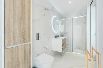 a white bedroom with a bed with white towels at The Sunny Duplex @ BoaVista Flats in Porto