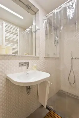 a white bathroom with a sink and a shower at Luiz I Optimum Lofts 00 in Porto